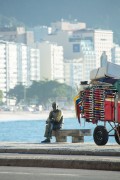 Statue of the poet Carlos Drummond de Andrade and cargo trolley on sidewalk of Copacabana Beach - Rio de Janeiro city - Rio de Janeiro state (RJ) - Brazil