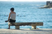 Woman sitting on a bench on the Copacabana Beach boardwalk - Rio de Janeiro city - Rio de Janeiro state (RJ) - Brazil