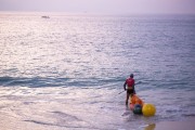 Swimming instructor entering the sea with kayak and signal buoys - Rio de Janeiro city - Rio de Janeiro state (RJ) - Brazil