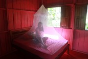Riverine woman of indigenous origin in a typical house - Bed with mosquito net - Manaus city - Amazonas state (AM) - Brazil