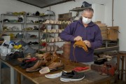Shoemaker during manual shoe repair using protective mask against Covid-19 - Guarani city - Minas Gerais state (MG) - Brazil
