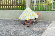Man under semi-enclosed beach tent on Arpoador boardwalk - Rio de Janeiro city - Rio de Janeiro state (RJ) - Brazil