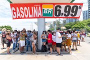 People protecting themselves from the sun under the coverage of a Petrobras gas station and a range with the price of gasoline of R$ 6.99 per liter - Demonstration in repudiation of the murder of Congolese refugee Moise Kabagambe near Post 8 - Rio de Janeiro city - Rio de Janeiro state (RJ) - Brazil