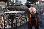 Construction worker holding board over head - Sao Paulo city - Sao Paulo state (SP) - Brazil