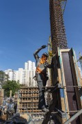 Construction worker nailing wooden box for concreting pillar wearing mask due to coronavirus pandemic - Sao Paulo city - Sao Paulo state (SP) - Brazil
