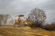 Grader machine clearing land burned by illegal fire for planting brachiaria grass - Guarani city - Minas Gerais state (MG) - Brazil