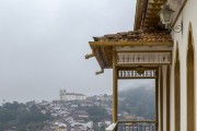 Detail of the balcony of a colonial house in the center of Ouro Preto with the Church of Santa Efigenia in the background - Ouro Preto city - Minas Gerais state (MG) - Brazil