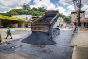 Bucket truck pouring asphalt mass for paving  Benedito Valadares street - Guarani city - Minas Gerais state (MG) - Brazil