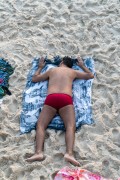 Man lying on the sand of Arpoador Beach - Rio de Janeiro city - Rio de Janeiro state (RJ) - Brazil