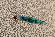 Picture taken with drone of riverine fisherman carrying a canoe on the dry bed of the Solimoes River - Careiro da Varzea city - Amazonas state (AM) - Brazil