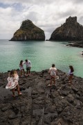 Tourists walking on the rocks in the Porcos Bay with Morro Dois Irmaos (Two Brothers Mountain) in the background - Fernando de Noronha Marine National Park - Fernando de Noronha city - Pernambuco state (PE) - Brazil