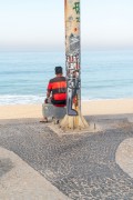 Graffiti on a lamp post and man dressed in a Flamengo shirt on Ipanema Beach - Rio de Janeiro city - Rio de Janeiro state (RJ) - Brazil