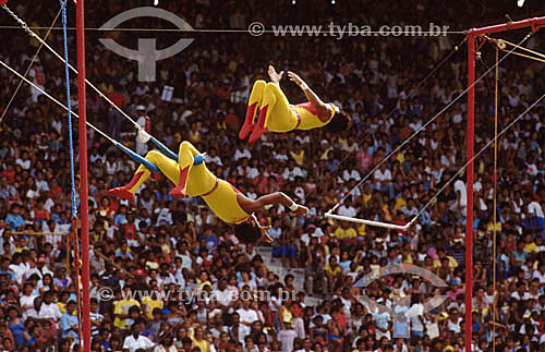  Trapezistas de circo com platéia ao fundo 