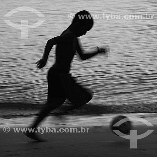  Futebol na praia - silhueta de menino jogando bola na beira da praia - Barra de Guaratiba - litoral sul do estado do RJ, próxima à Restinga da Marambaia - Rio de Janeiro - Brasil  - Rio de Janeiro - Rio de Janeiro - Brasil