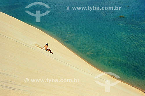  Jovem deslizando na duna em Jericoacoara - CE - Brasil  - Jijoca de Jericoacoara - Ceará - Brasil