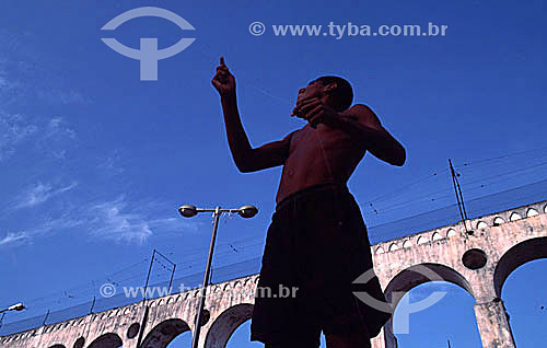  Menino empinando pipa em frente aos Arcos da Lapa - Centro do Rio de Janeiro - RJ - Brasil

  Aqueduto em estilo romano do século XVIII (Rio colonial), com uma dupla arcada de 42 arcos. Patrimônio Histórico Nacional desde 05-04-1938.  - Rio de Janeiro - Rio de Janeiro - Brasil