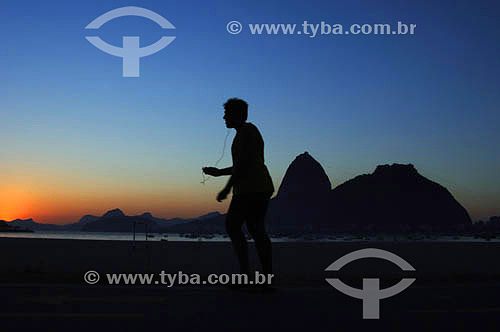  Lazer - silhueta de pessoa caminhando com o Pão de Açúcar  ao fundo - Praia de Botafogo - Rio de Janeiro - RJ - Brasil - obs.:foto digital   é comum chamarmos de Pão de Açúcar o conjunto da formação rochosa que inclui o Morro da Urca e o próprio Morro do Pão de Açúcar (o mais alto dos dois). O conjunto rochoso é Patrimônio Histórico Nacional desde 08-08-1973.  - Rio de Janeiro - Rio de Janeiro - Brasil