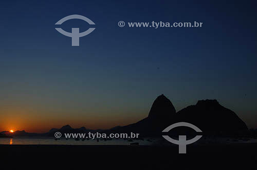  Silhueta do Pão de Açúcar  com sol nascendo - Praia de Botafogo - Rio de Janeiro - RJ - Brasil - obs.:foto digital   é comum chamarmos de Pão de Açúcar o conjunto da formação rochosa que inclui o Morro da Urca e o próprio Morro do Pão de Açúcar (o mais alto dos dois). O conjunto rochoso é Patrimônio Histórico Nacional desde 08-08-1973.  - Rio de Janeiro - Rio de Janeiro - Brasil