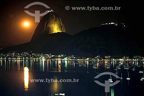  Silhueta do Pão de Açúcar   à noite com os barcos e as luzes do bairro da Urca abaixo - Rio de Janeiro - RJ - Brasil

  é comum chamarmos de Pão de Açúcar, o conjunto da formação rochosa que inclui o Morro da Urca e o próprio Morro do Pão de Açúcar (o mais alto dos dois). O conjunto rochoso é Patrimônio Histórico Nacional desde 08-08-1973.  - Rio de Janeiro - Rio de Janeiro - Brasil