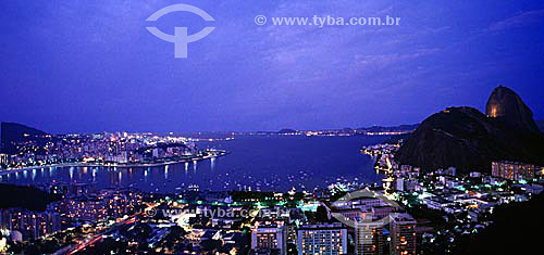  Vista panorâmica do Pão de Açúcar  no crepúsculo com as luzes da enseada de Botafogo abaixo, os bairros do Flamengo à esquerda e da Urca à direita e a cidade de Niterói ao fundo - Rio de Janeiro - RJ - Brasil

  é comum chamarmos de Pão de Açúcar, o conjunto da formação rochosa que inclui o Morro da Urca e o próprio Morro do Pão de Açúcar (o mais alto dos dois).  O conjunto rochoso é Patrimônio Histórico Nacional desde 08-08-1973.  - Rio de Janeiro - Rio de Janeiro - Brasil