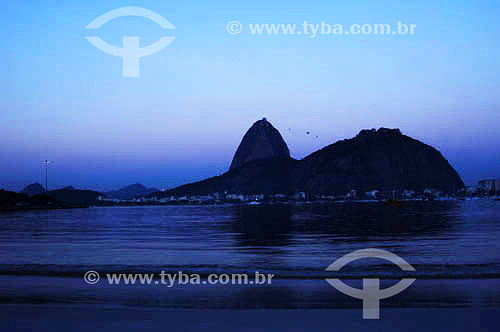  Silhueta do Pão de Açúcar  - Praia de Botafogo - Rio de Janeiro - RJ - Brasil - obs.:foto digital 

  é comum chamarmos de Pão de Açúcar o conjunto da formação rochosa que inclui o Morro da Urca e o próprio Morro do Pão de Açúcar (o mais alto dos dois). O conjunto rochoso é Patrimônio Histórico Nacional desde 08-08-1973.  - Rio de Janeiro - Rio de Janeiro - Brasil