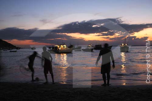  Silhueta de meninos jogando futebol na beira da praia com embarcações no mar, ao fundo - Barra de Guaratiba, litoral sul - Rio de Janeiro - Brasil  foto digital  - Rio de Janeiro - Rio de Janeiro - Brasil