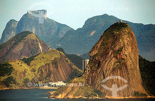  Vista do Pão de Açúcar (1) mostrando, em primeiro plano, o Morro Cara de Cão; a Praia Vermelha à esquerda seguida do Morro da Babilônia (2) ao fundo vemos a Pedra da Gávea  - Rio de Janeiro - RJ - Brasil 

(1) é comum chamarmos de Pão de Açúcar, o conjunto da formação rochosa que inclui o Morro da Urca e o próprio Morro do Pão de Açúcar (o mais alto dos dois). O conjunto rochoso é Patrimônio Histórico Nacional desde 08-08-1973. 
(2) é chamada de Morro da Babilônia a encosta voltada para o bairro da Urca, sendo que a encosta voltada para o Leme e Copacabana - incluindo a parte mais projetada sobre o oceano à esquerda -  é chamada de Morro do Leme.  é Patrimônio Histórico Nacional desde 08-08-1973.  foto digital  - Rio de Janeiro - Rio de Janeiro - Brasil