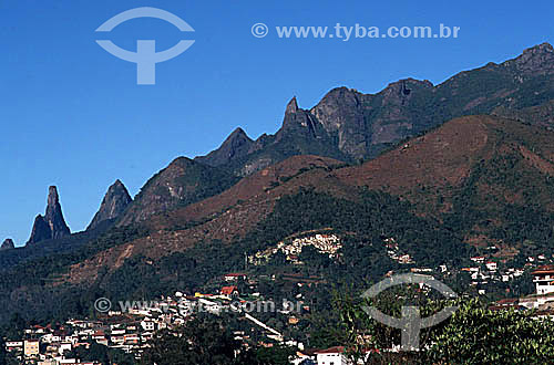  Vista da cidade de Teresópolis com a silhueta do relevo montanhoso do Parque Nacional da Serra dos Órgãos ao fundo, no qual se destaca o Dedo de Deus à esquerda, pico assim denominado por sugerir a forma de um dedo indicador apontado para o céu - Teresópolis - Região serrana do estado do Rio de Janeiro - Brasil  - Teresópolis - Rio de Janeiro - Brasil