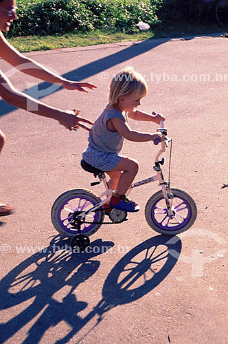  Mãe ajudando criança à andar de bicicleta 