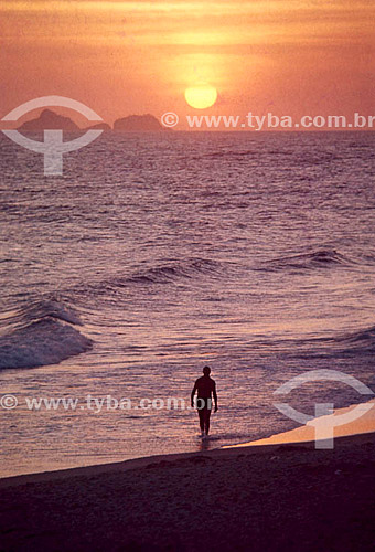  Pessoa andando na praia no pôr-do-sol 