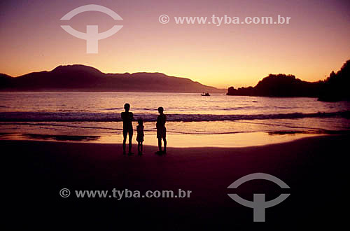  Casal andando na praia no pôr-do-sol 