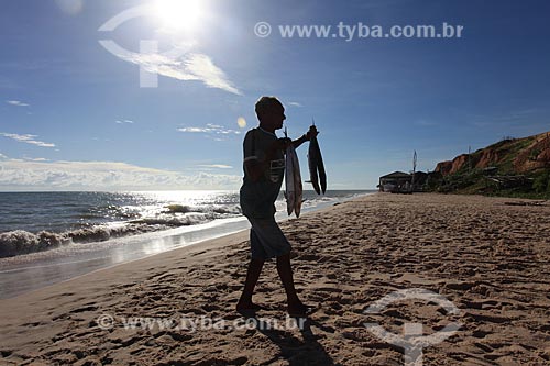  Assunto: Pescador com peixes na mãos na praia de Canoa Quebrada / Local: Aracati - Ceará (CE) - Brasil / Data: 03/2011 