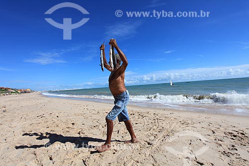  Assunto: Pescador com peixes na mãos na praia de Canoa Quebrada / Local: Aracati - Ceará (CE) - Brasil / Data: 03/2011 