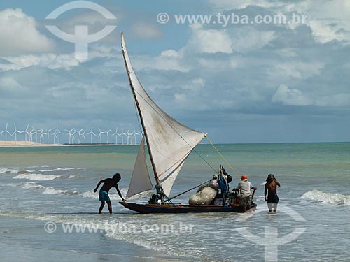  Assunto: Jangada com pescadores na praia de Canoa Quebrada ao fundo aerogeradores / Local: Aracati - Ceará (CE) - Brasil / Data: 03/2011 