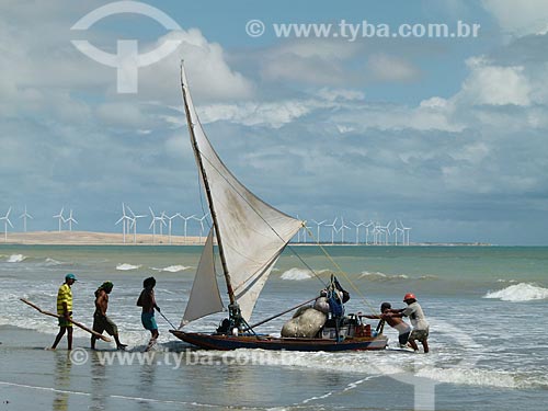  Assunto: Jangada com pescadores na praia de Canoa Quebrada ao fundo aerogeradores / Local: Aracati - Ceará (CE) - Brasil / Data: 03/2011 