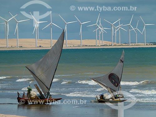  Assunto: Jangadas com pescadores na praia de Canoa Quebrada ao fundo aerogeradores / Local: Aracati - Ceará (CE) - Brasil / Data: 03/2011 