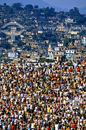  Assunto: Público em arquibancada no Sambódromo da Marquês de Sapucaí com favela ao fundo / Local: Rio de Janeiro (RJ) - Brasil / Data: 1988 