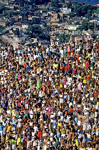  Assunto: Público em arquibancada no Sambódromo da Marquês de Sapucaí com favela ao fundo / Local: Rio de Janeiro (RJ) - Brasil / Data: 1988 