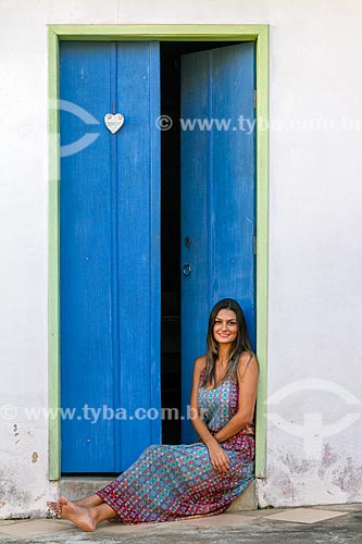  Detalhe de jovem mulher sentada em frente à porta  - Guarani - Minas Gerais (MG) - Brasil