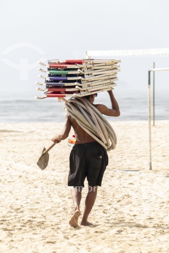 Trabalhador carregando cadeiras de praia para aluguel - Rio de Janeiro - Rio de Janeiro (RJ) - Brasil