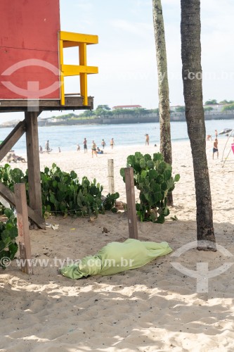 Morador de rua dormindo na areia da Praia de Copacabana embaixo de guarita de salva-vidas - Rio de Janeiro - Rio de Janeiro (RJ) - Brasil