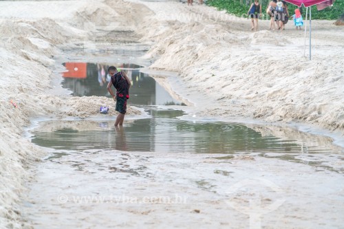 Criança brincando em saída de esgoto (lingua negra) no Posto 5 da Praia de Copacabana - Rio de Janeiro - Rio de Janeiro (RJ) - Brasil