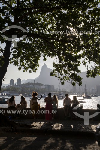 Pessoas se socializando e bebendo sentadas à beira-mar na Mureta da Urca - Rio de Janeiro - Rio de Janeiro (RJ) - Brasil