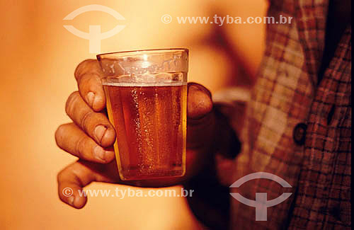  Detail of the hand of a man holding a cup with beer 