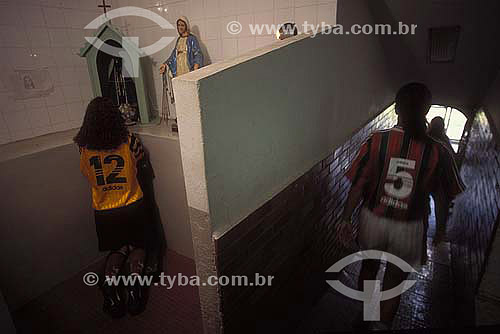  A goalkeeper praying before a womem soccer match 