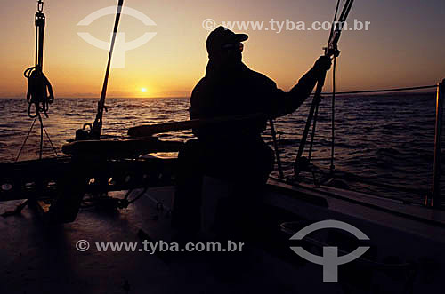  Silhouette of a man on the sailing boat at sunset - fluminense south coast - Rio de Janeiro state - Brazil 