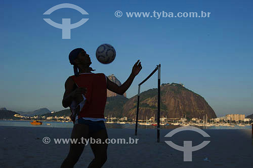  Silhouette of man playing football at the Botafogo Beach with the Sugar Loaf Mountain in the background - Rio de Janeiro city - Rio de Janeiro state - Brazil 