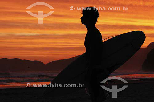  Surfer silhouette holding a surf board 