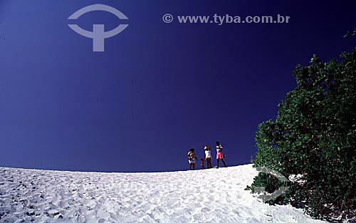 People walking on the dunes of white sand of Lagoa de Abaeté (Abaete Lagoon) - Salvador city - Bahia state - Brazil 
