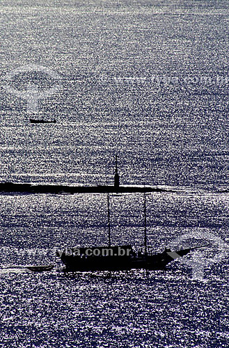  Sailing boat silhouette crossing the sea silvered by the sunset in Bahia - Brazil 